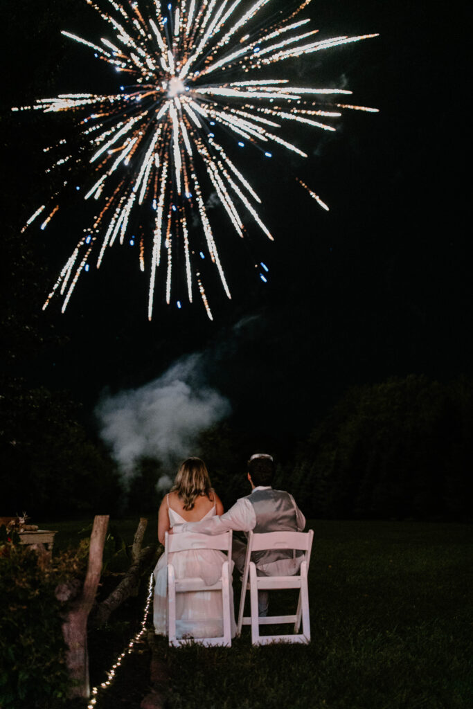 bride and groom enjoying fireworks at their intimate backyard wedding reception